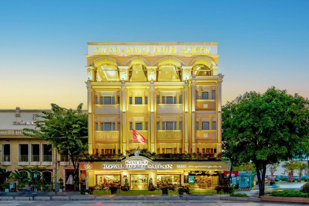 ein großes gelbes Gebäude mit einem Schild darauf in der Unterkunft Royal Hotel Saigon in Ho-Chi-Minh-Stadt