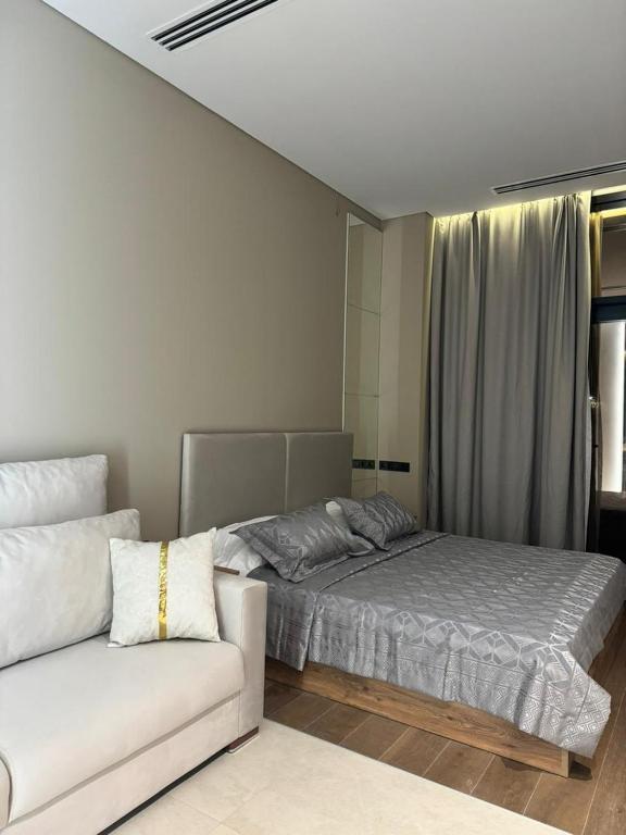 a bedroom with a bed and a couch at Sea Breeze Lighthouse 3 Studio ML in Nardaran
