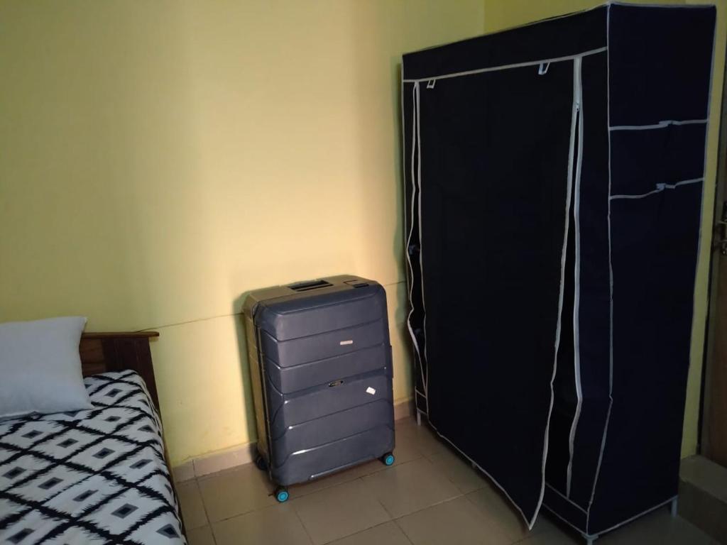 a bedroom with a suitcase next to a bed at Unique in Ouagadougou