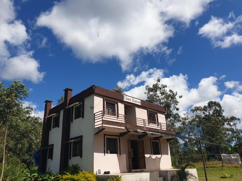 a white building with a balcony on top of it at Chez Rasoa Andasibe in Moramanga