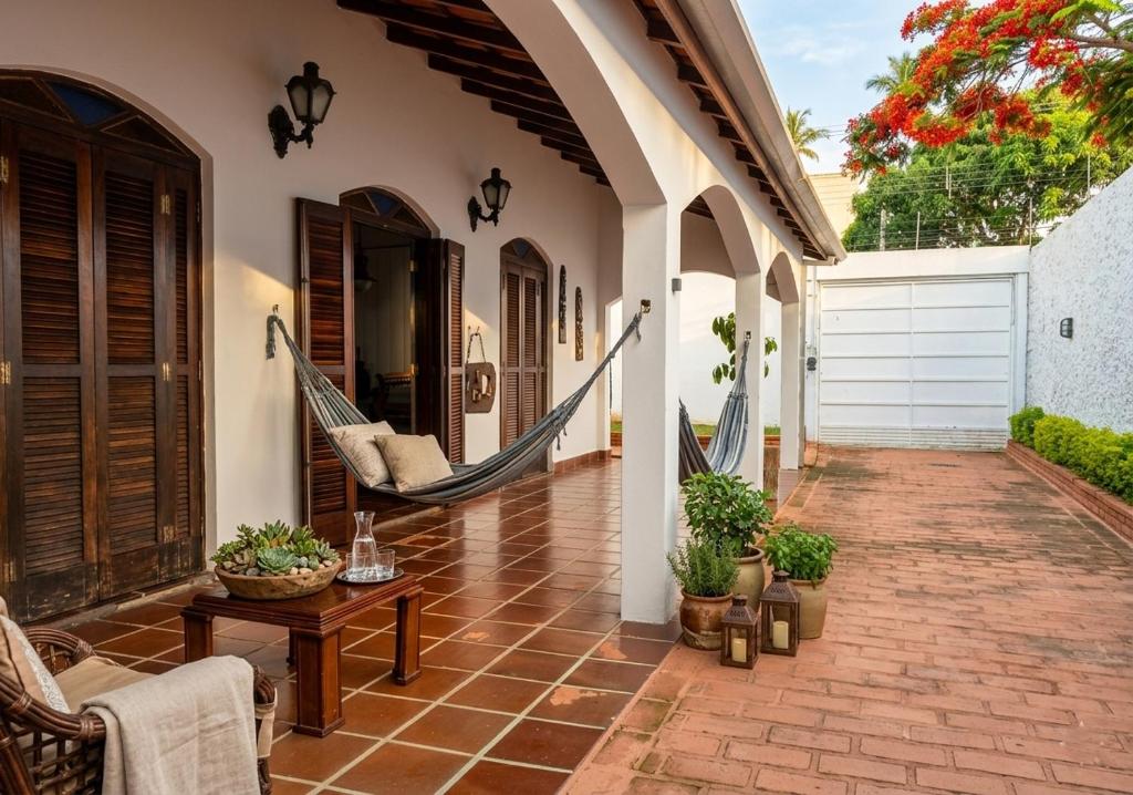 a porch with a hammock on a house at Casa Aconchegante para até 6 Pessoas a 100m do Mar in São Sebastião