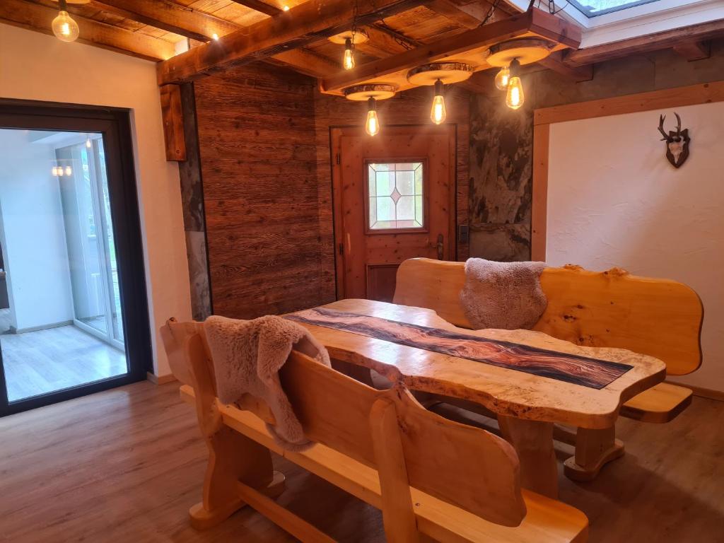 a dining room with a wooden table and a couch at Ferienwohnung Colleen in Fügenberg