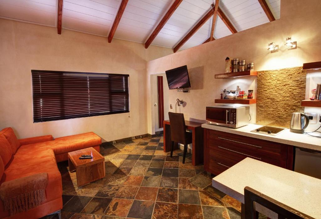 een keuken met een woonkamer met een bank en een tafel bij Hartmann Suites Serviced Self-Catering Apartments in Windhoek