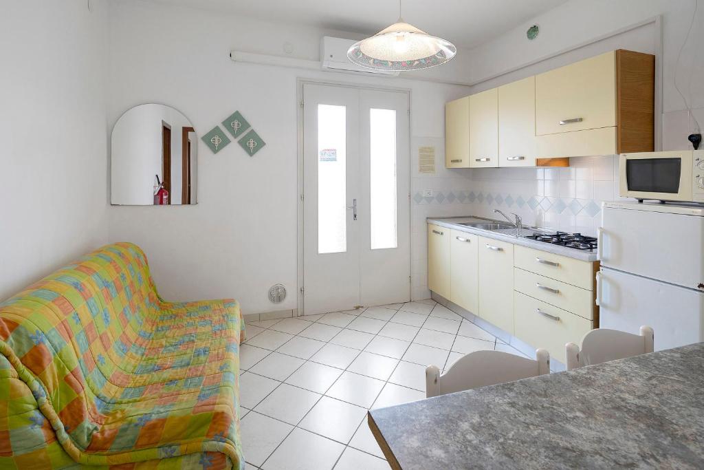 a kitchen with a couch and a chair in a room at Residenza Stella X in Bibione