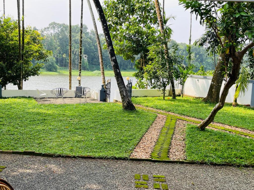 a park with trees and grass and a body of water at The River House in Cochin