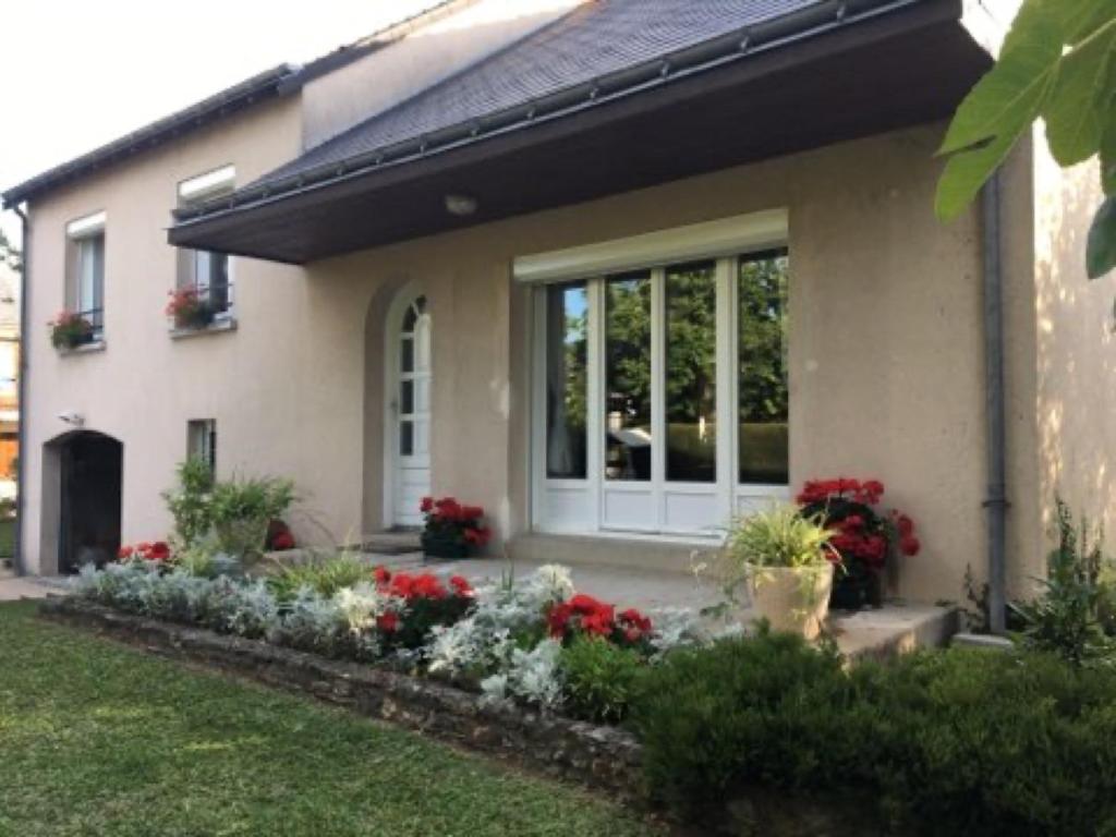 a house with flowers in the front yard at Chambres Du Bois Des Hâtes in Saint-Avertin