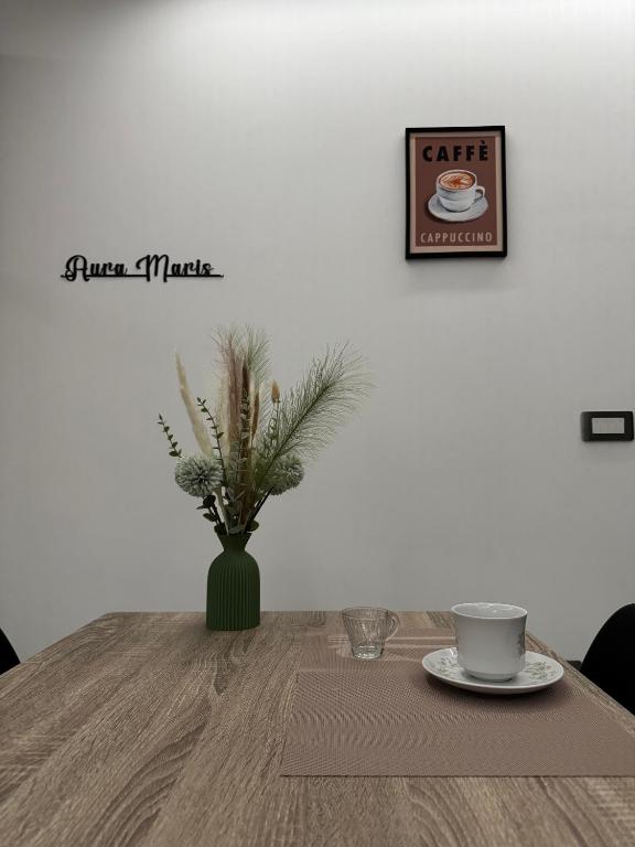 a table with a vase with a cup of coffee on it at Aura Maris in Guspini