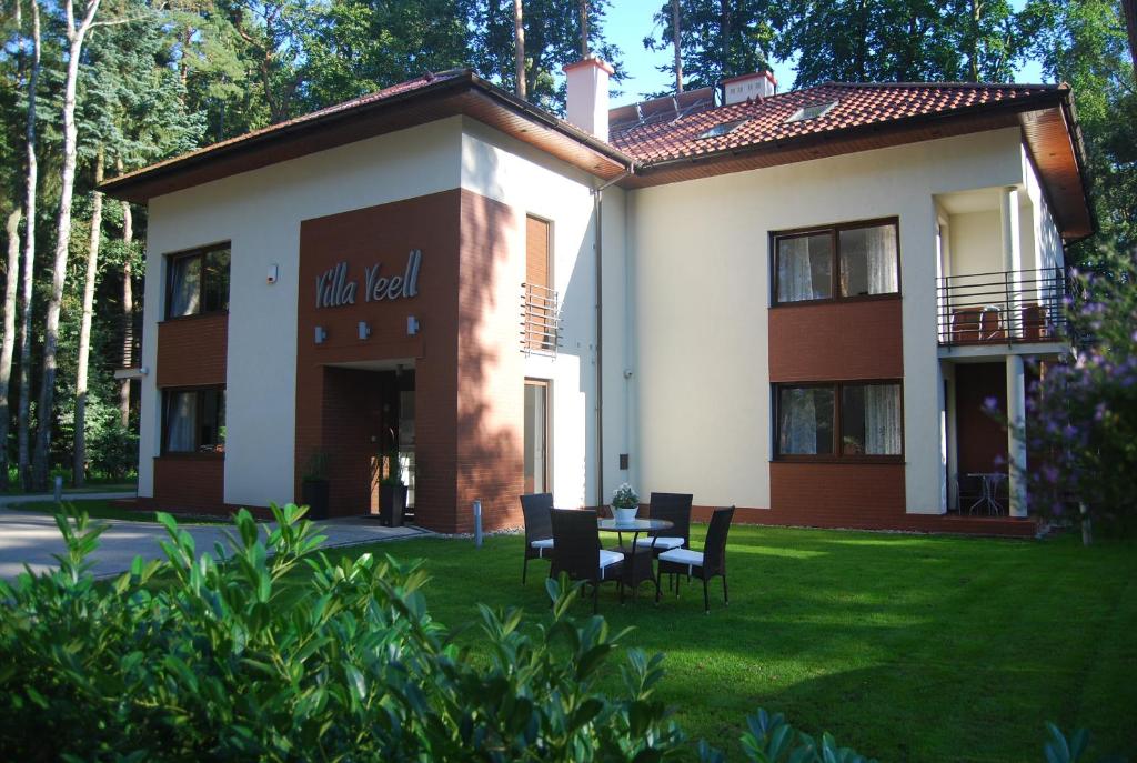 a building with a table and chairs in the yard at Villa Veell - tylko 4 minuty od pięknej szerokiej plaży in Pobierowo
