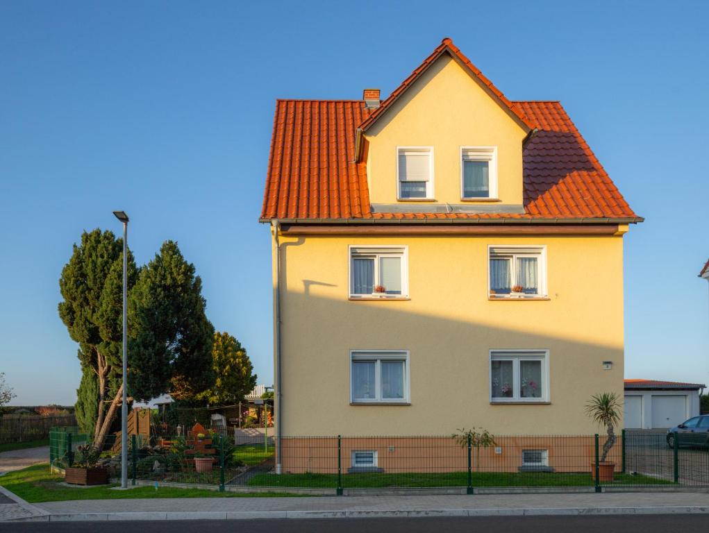a yellow house with an orange roof at Ferienwohnung Tietze in Fockendorf