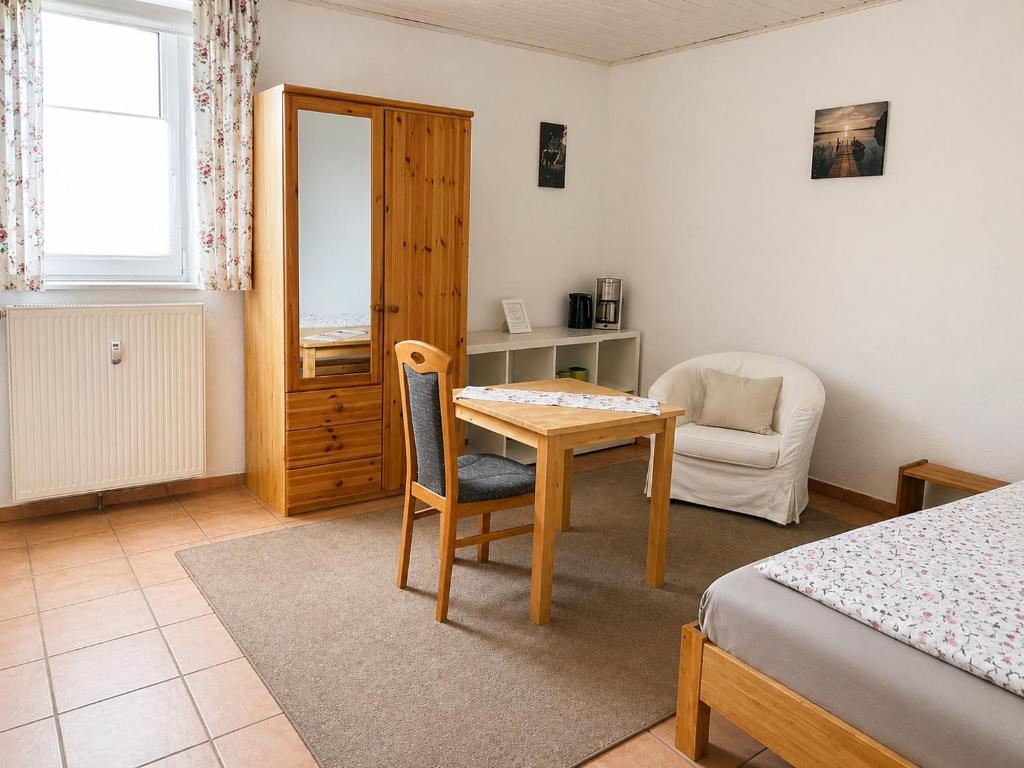 a bedroom with a table and a chair and a desk at Pension Pohl in Wenden