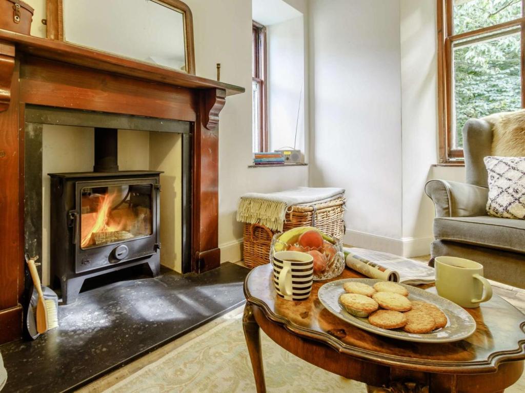 a living room with a fireplace and a table with cookies at 2 Bed in Cupar oc-78228 in Ceres