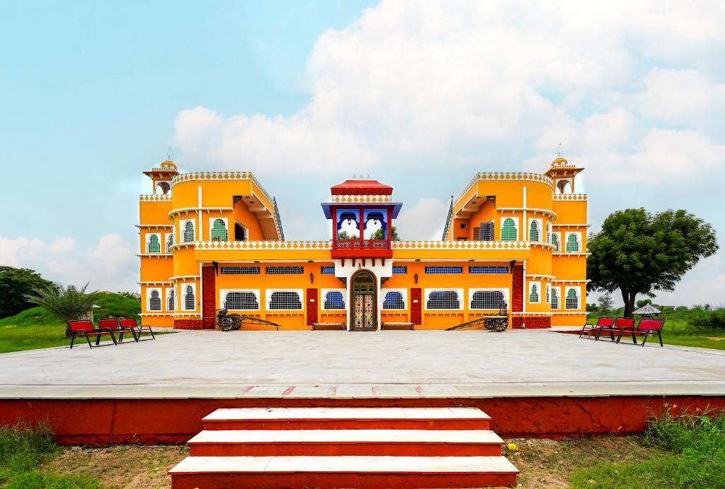 a large orange building with a clock tower on it at Hotel Goram Garh Resort in Pāli