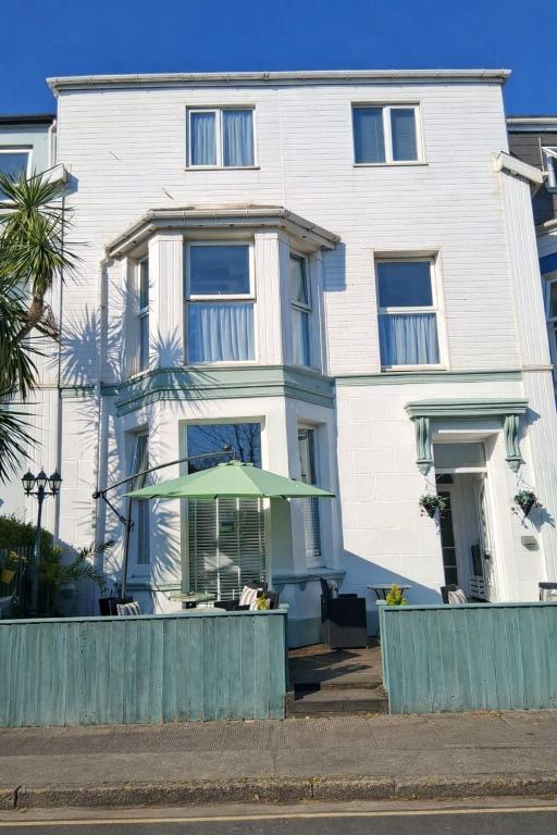 a white building with a green umbrella in front of it at Barbican Paignton in Paignton
