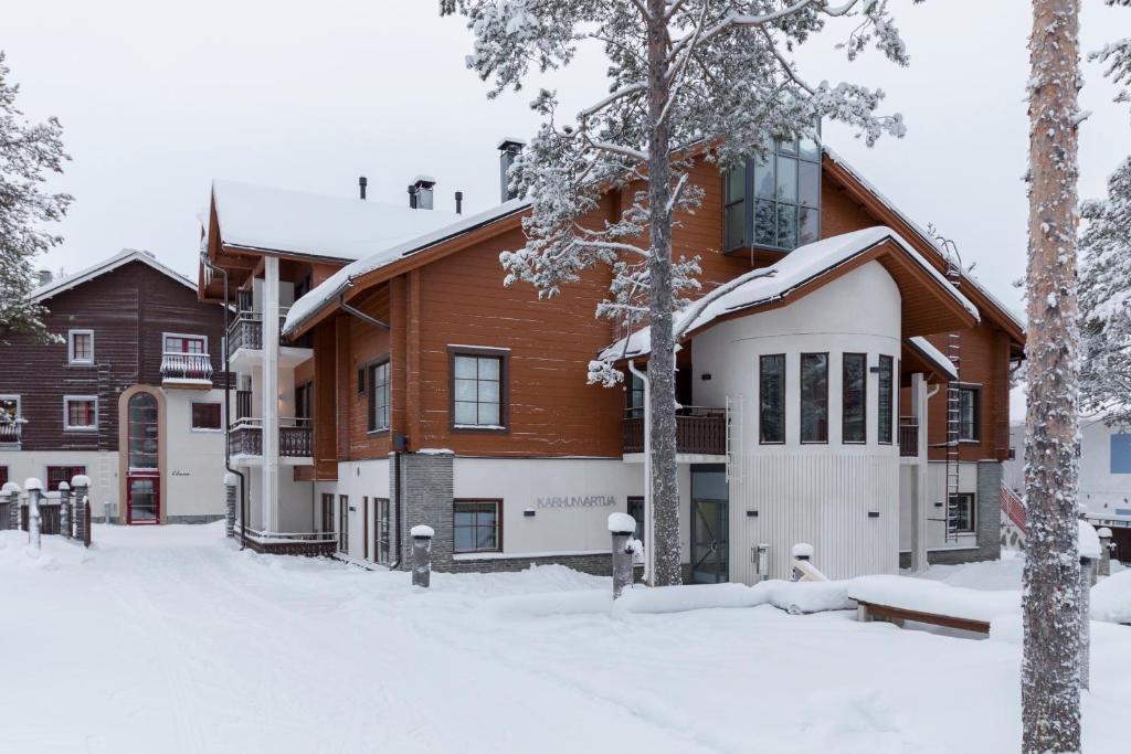 a house with snow on the ground in front of it at Karhunvartija 11 Visit Levi in Sirkka