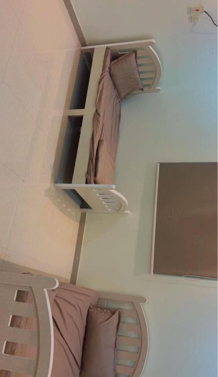 two twin beds in a room with shelves at Alnozhah in Ḑurumā