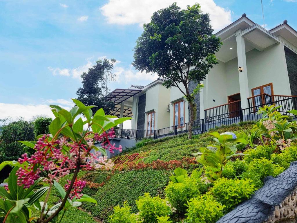 a house on top of a hill with flowers at Moya Villa & Resto in Cihideung