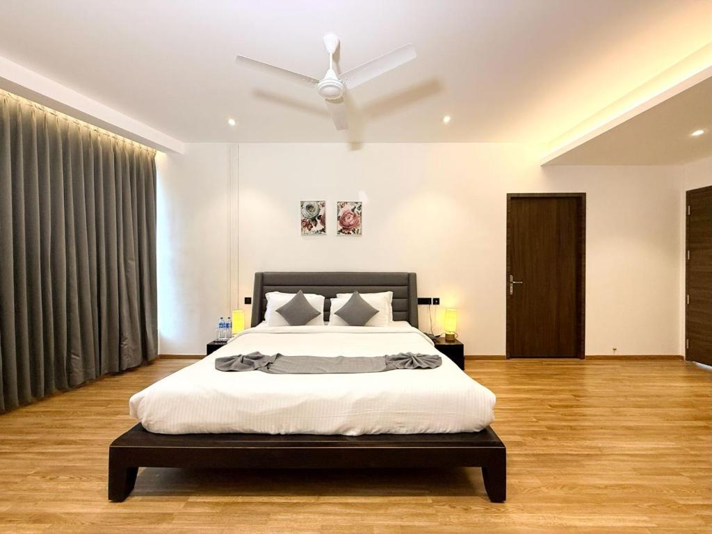 a bedroom with a bed and a ceiling fan at The Residence by Chakolas Pavilion in Cochin