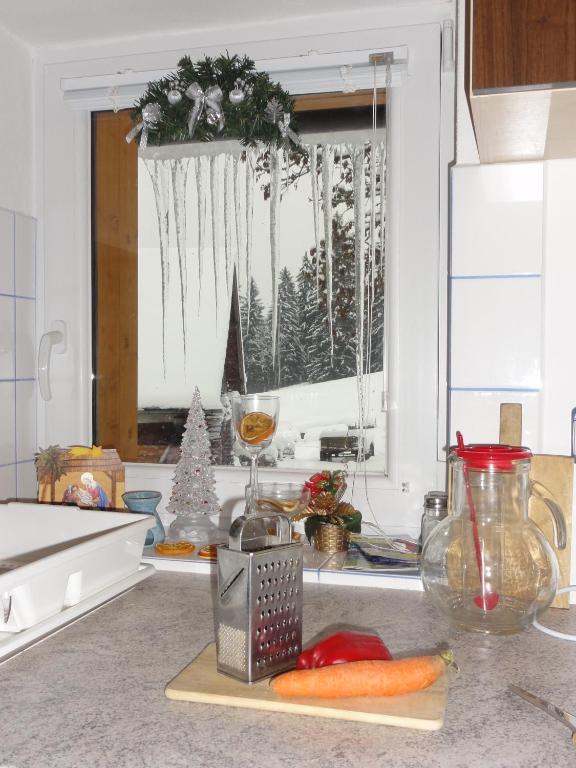 a kitchen counter with a window with christmas decorations at Apartmány Kuřátko in Benecko