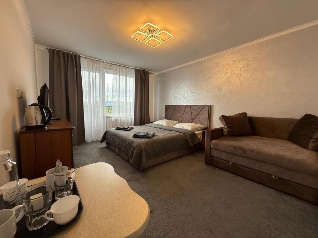 a hotel room with a bed and a couch at Квітуча Гора Double Room in Lazeshchyna