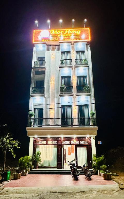 a tall building with a sign on top of it at Mộc Hưng Homestay in Bắc Hà