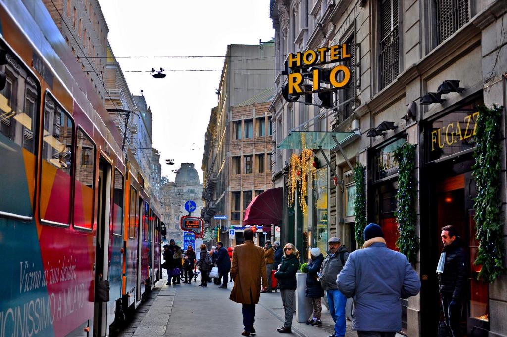 a group of people walking down a busy city street at Hotel Rio in Milan