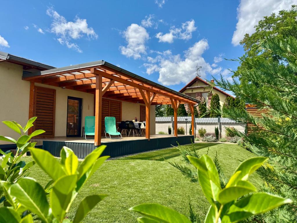 a pergola on a house with a yard at Chata VeloVino in Moča