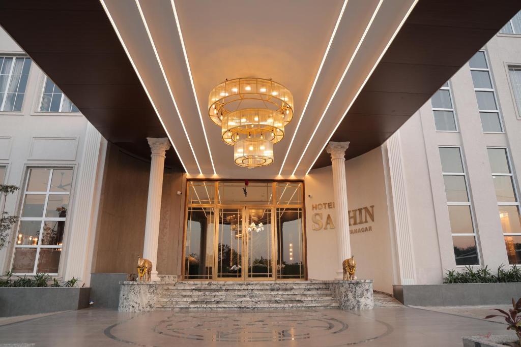 a lobby of a building with a chandelier at Hotel Sachin in Chas