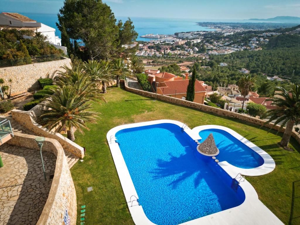 a blue swimming pool on the side of a villa at Alcossebre Panorama Suite, Piscina y Terraza con Vistas in Alcossebre