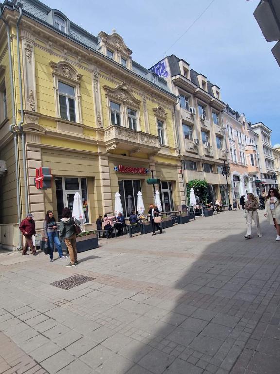 a group of people walking on a city street at Elena Apartments in Absolute Center in Ruse