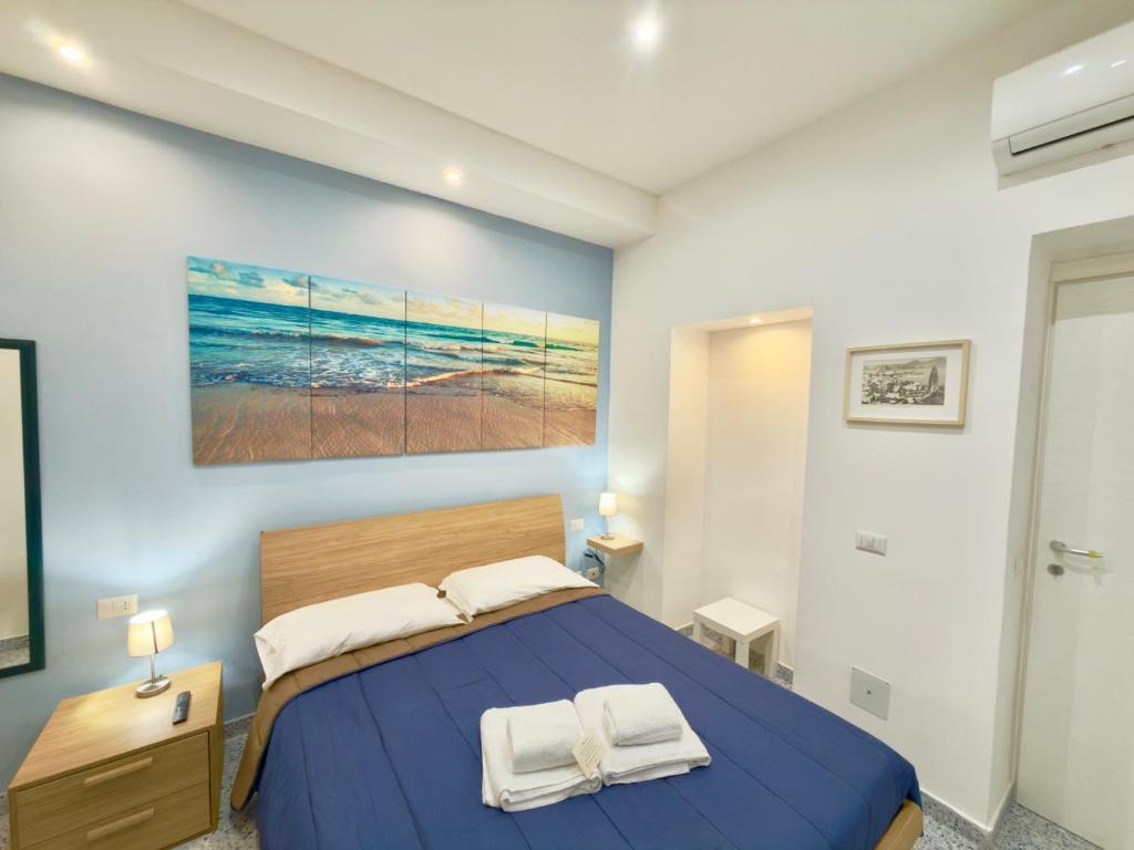 a bedroom with a bed and a painting on the wall at VICO 11 Gaeta - UN LETTO IDEALE in Gaeta