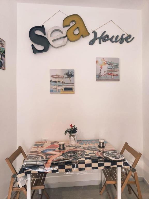 a table with chairs and a sign that reads so house at Sea House in Taranto