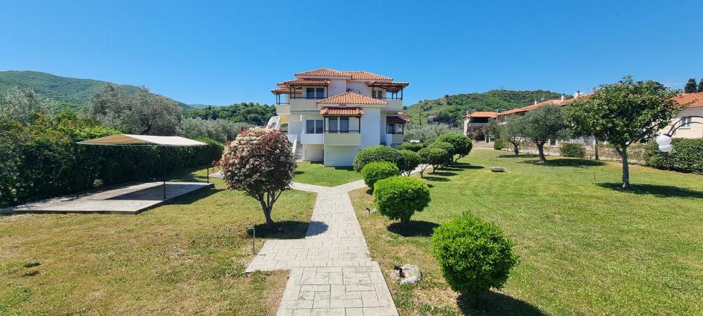 a house with a walkway in front of a yard at 5 Suites Αγιόκαμπος Αγιάς in Agiokampos