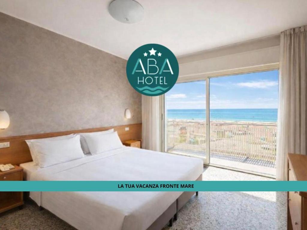 a hotel room with a bed and a large window at Hotel ABA FRONTE MARE in Milano Marittima