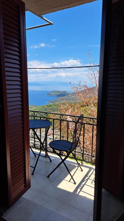 a table and chair on a balcony with a view of the ocean at Serafima's house Lesvos in Sykaminéa
