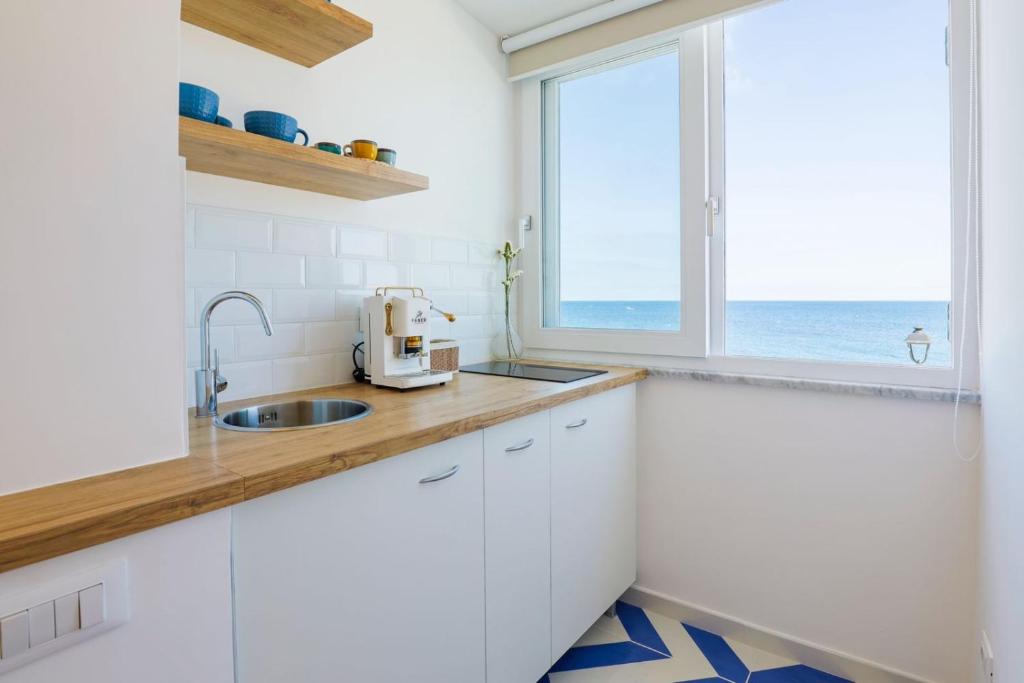 a kitchen with a sink and a window at Isabel Luxury Suite in Ischia
