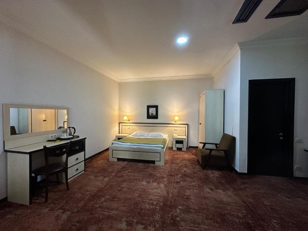 a hotel room with a bed and a desk and a desk at Hotel Cash in Tbilisi City
