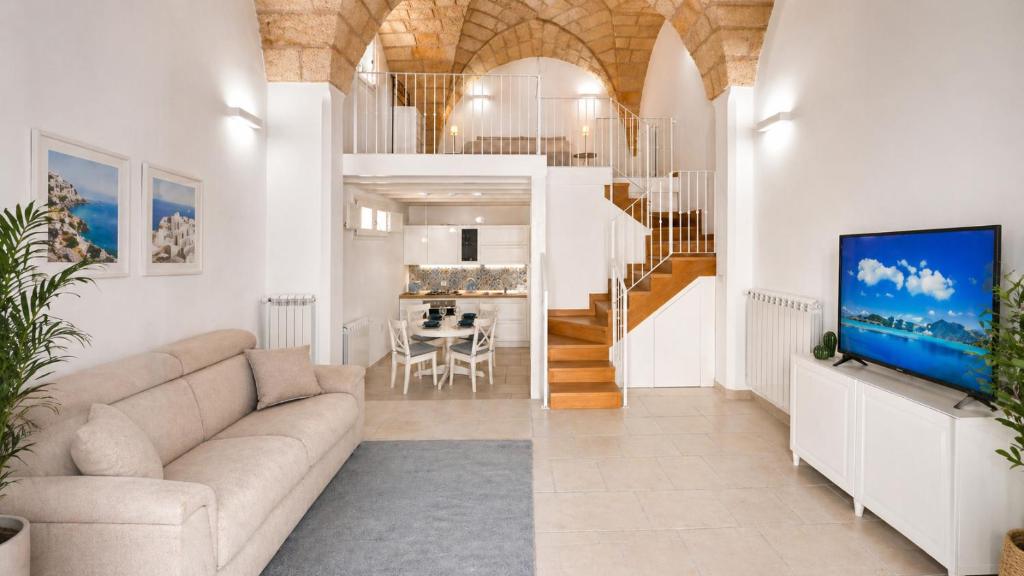 a living room with a couch and a tv at Corte Nizza in Taviano