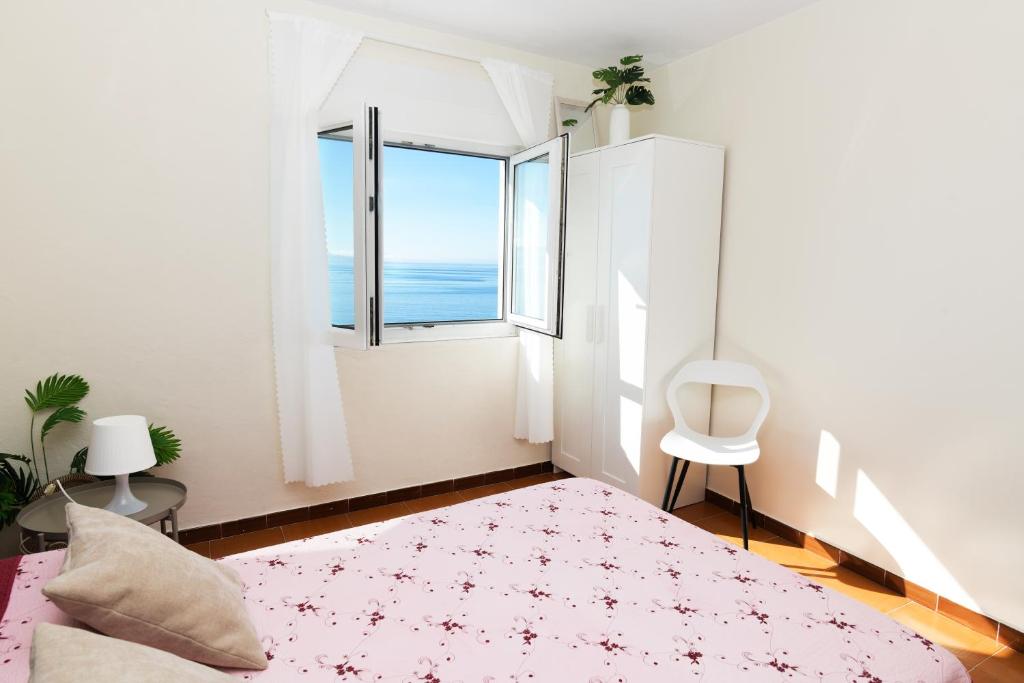 a bedroom with a bed and a large window at Casa Marzoa in Finisterre