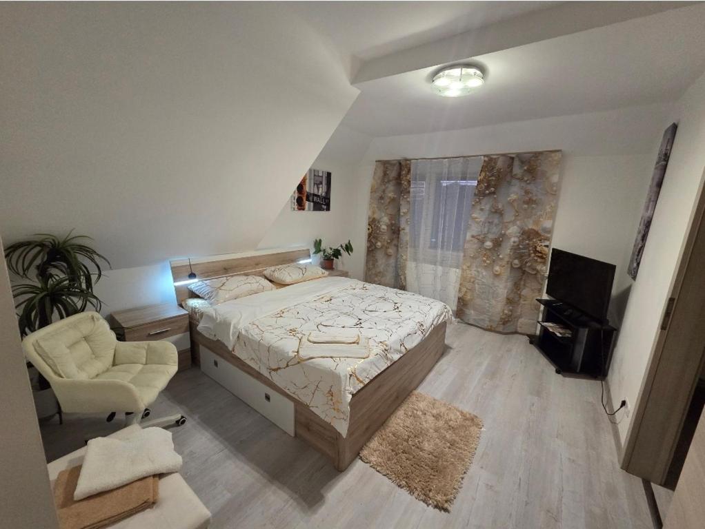 a bedroom with a bed and a chair and a television at 4 Apartments Angels o k b in Altenburg