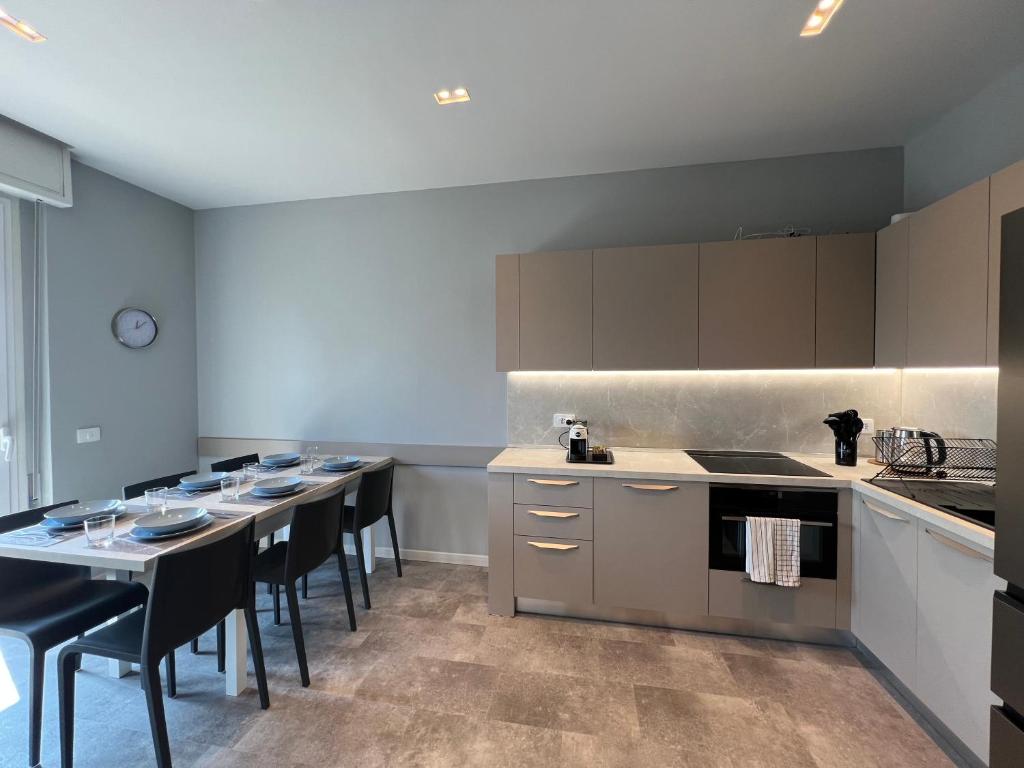 a kitchen with a bunch of tables and chairs at Appartamento Ideal con piscine e animazione Hotel Alba d Oro estate in Gatteo a Mare