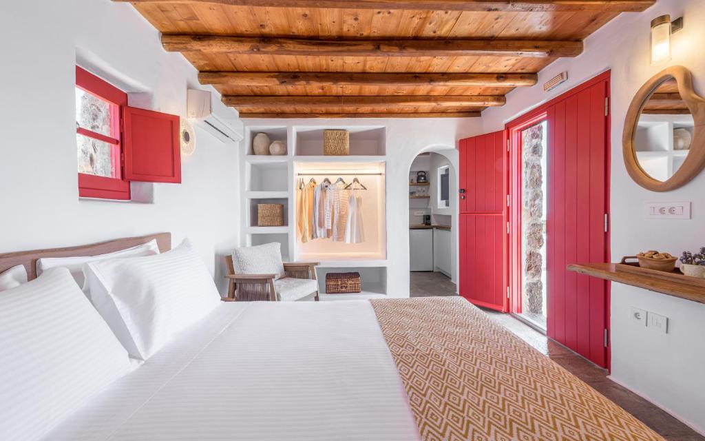 a bedroom with red doors and a white bed at Marketos Windmill House in Tripiti