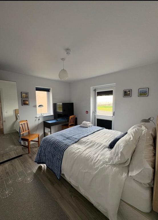a bedroom with a large bed and a desk at Housegarth in Twatt