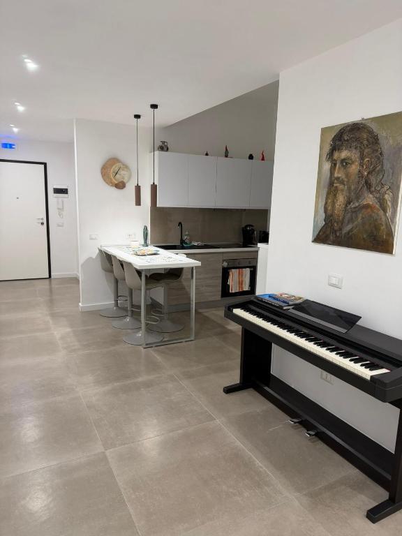 a piano in a kitchen with a table and a painting at B&B Sparta in Crotone