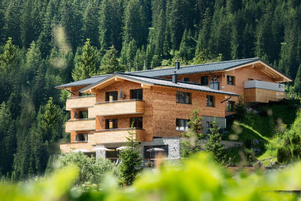 a large building in the middle of a forest at Mats Lech Alpenquartier in Lech am Arlberg