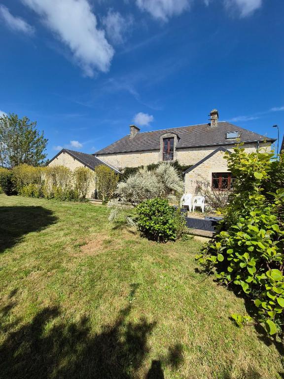 a house with two white chairs in a yard at Le Longbeach 1 in Longueville