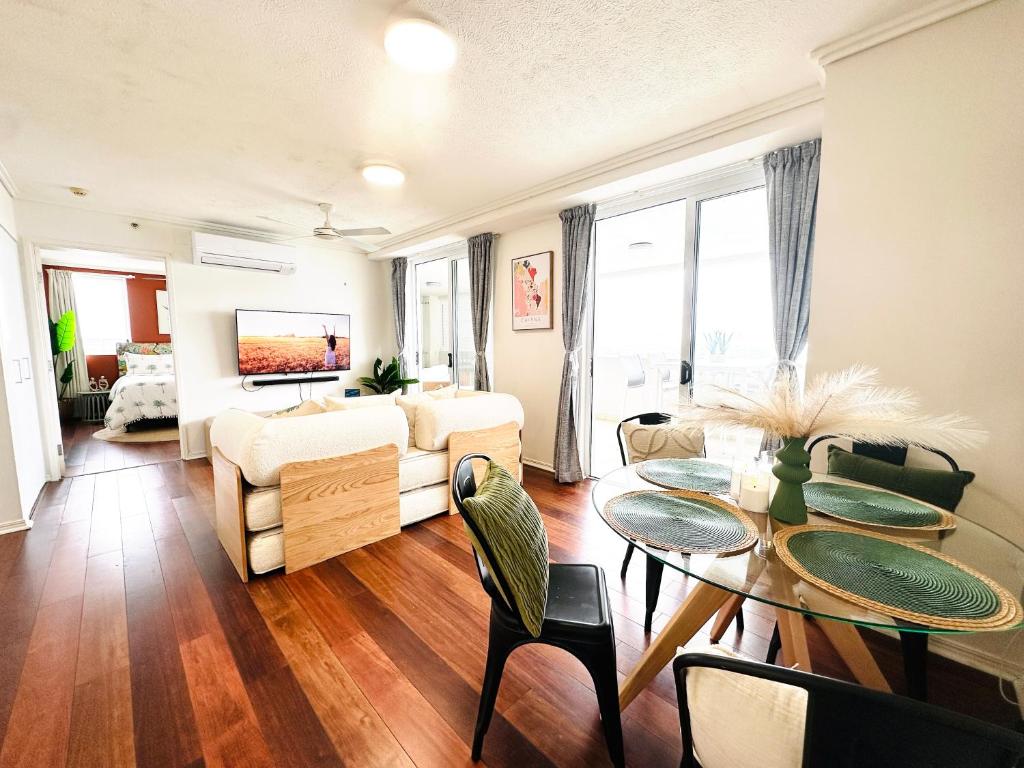 a living room with a table and a couch at Prime CBD High Rise Apartment in Cairns