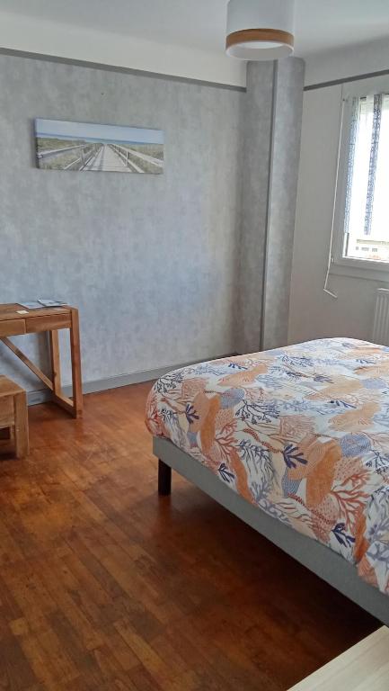 a bedroom with a bed and a wooden floor at Le lagon zen in Ploufragan