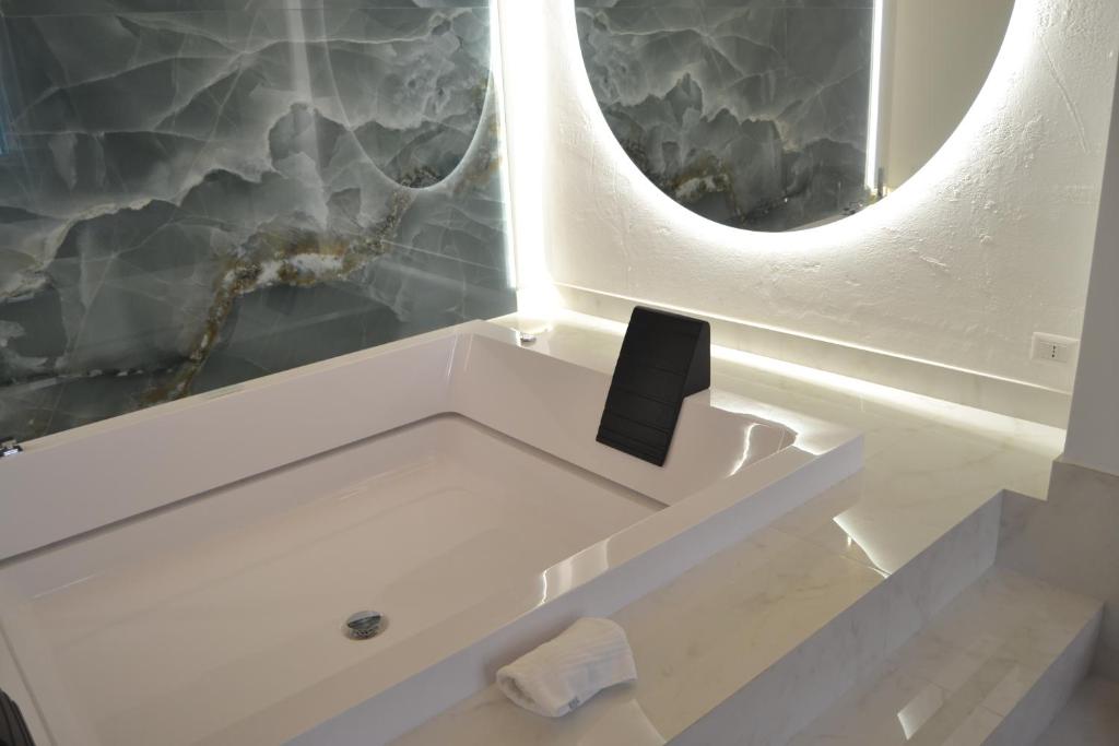 a bathroom with a white bath tub with a mirror at DuOr Suite & Rooms in Polignano a Mare