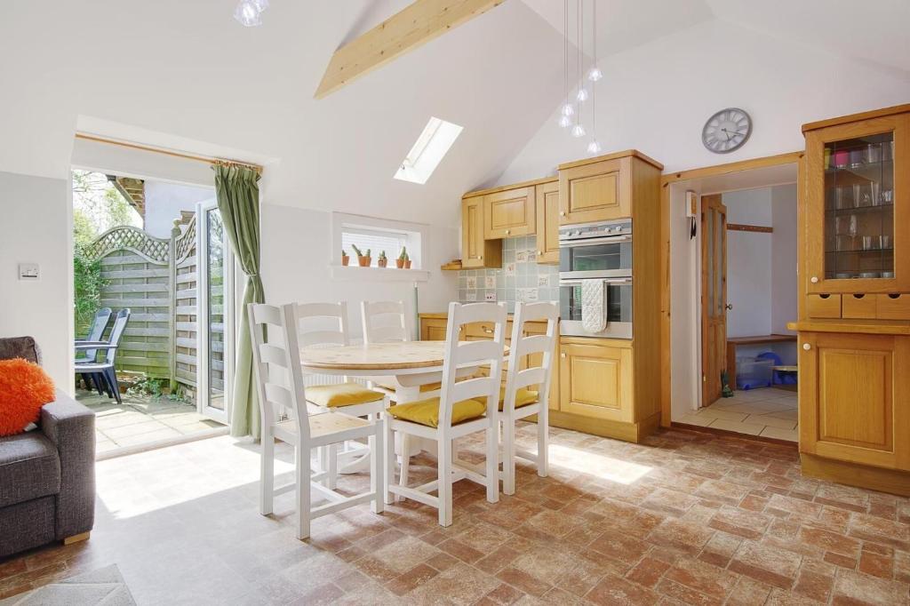 a kitchen with a table and chairs in a room at The Stables Hill Top Farm in Haselbury Bryan