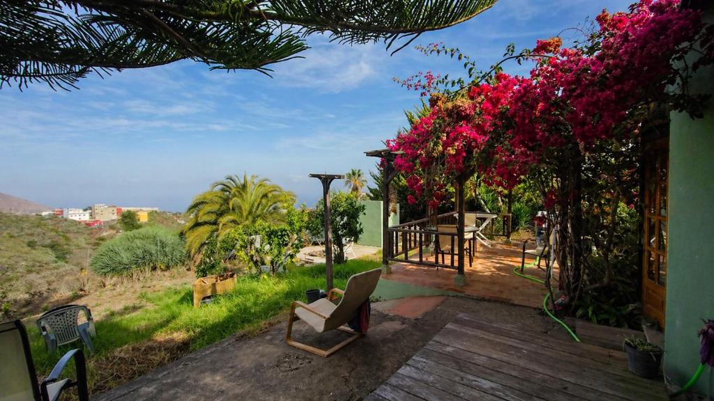 a house with a deck with pink flowers on it at The Good Vibes Home in Hoya de Pineda